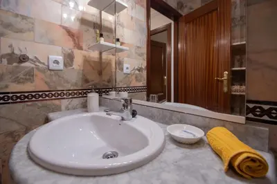 a bathroom with a white sink and a mirror at Apartamento Nuestra Andalucia - Cadiz Centro - parking in Cádiz