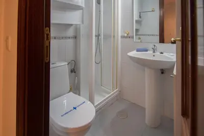 a white bathroom with a toilet and a sink at Apartamento Nuestra Andalucia - Cadiz Centro - parking in Cádiz