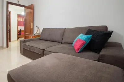 a living room with a brown couch with two pillows at Apartamento Nuestra Andalucia - Cadiz Centro - parking in Cádiz