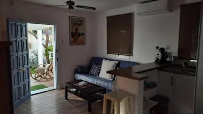 a living room with a blue couch and a table at Casa con encanto junto a la playa de La Puntilla in El Puerto de Santa María