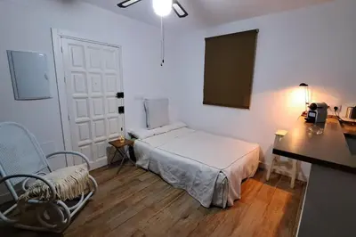 a bedroom with a bed and a table and a desk at Casa con encanto junto a la playa de La Puntilla in El Puerto de Santa María