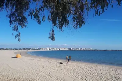 two people walking on a beach near the water at Casa con encanto junto a la playa de La Puntilla in El Puerto de Santa María