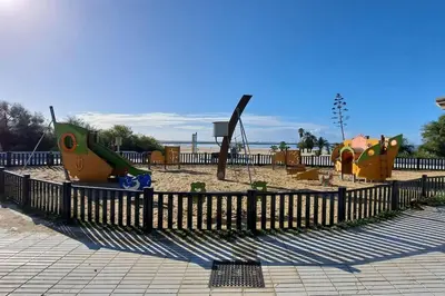 a playground with two play equipment in a park at Casa con encanto junto a la playa de La Puntilla in El Puerto de Santa María