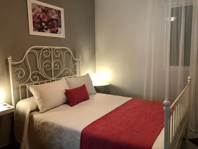 a bedroom with a white bed with a red blanket at Casa grande con piscina in Rota