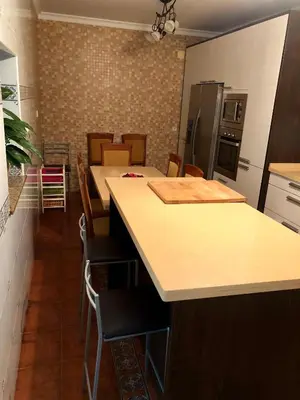a kitchen with a island with chairs and a counter top at Casa grande con piscina in Rota