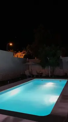 a large blue swimming pool lit up at night at Casa grande con piscina in Rota
