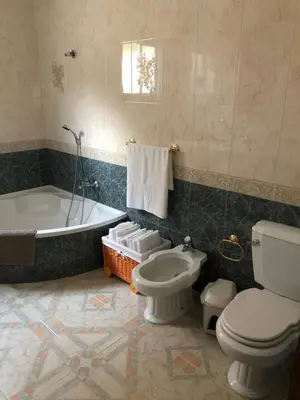 a bathroom with a toilet and a tub and a sink at Casa grande con piscina in Rota