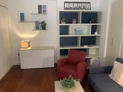 a living room with a red chair and a couch at Estudio Alameda in Cádiz