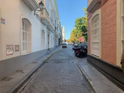 an empty street with motorcycles parked on the side of buildings at Estudio Alameda in Cádiz