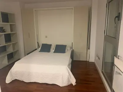 a bedroom with a white bed with blue pillows at Estudio Alameda in Cádiz
