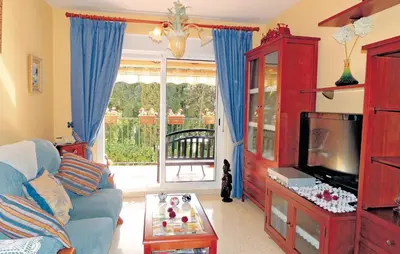 a living room with a blue couch and a tv at Cozy Apartment In Jerez De La Frontera in Jerez de la Frontera