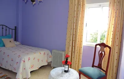 a bedroom with a bed and a chair and a window at Cozy Apartment In Jerez De La Frontera in Jerez de la Frontera