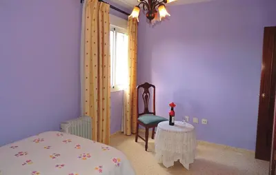 a bedroom with a bed and a chair and a table at Cozy Apartment In Jerez De La Frontera in Jerez de la Frontera