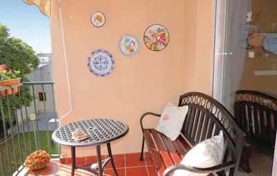 a balcony with a bench and plates on the wall at Cozy Apartment In Jerez De La Frontera in Jerez de la Frontera