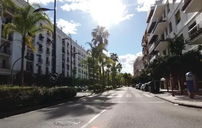 an empty city street with palm trees and buildings at Cozy Apartment In Jerez De La Frontera in Jerez de la Frontera