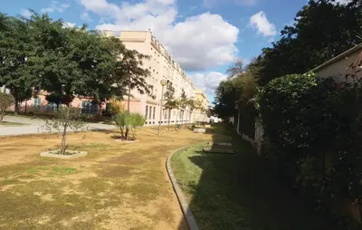 a view of a building with a yard with benches at Cozy Apartment In Jerez De La Frontera in Jerez de la Frontera