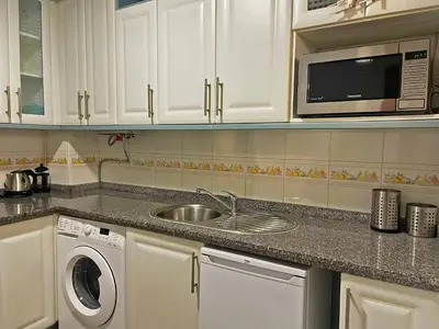 a kitchen with a sink and a microwave at Apartamento Armas - Ole Solutions in Jerez de la Frontera