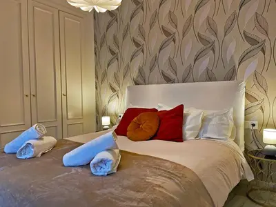 a bed with three pillows on it in a bedroom at Apartamento Armas - Ole Solutions in Jerez de la Frontera