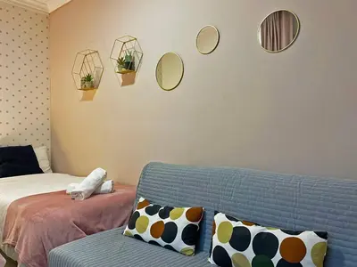 a living room with a couch and mirrors on the wall at Apartamento Armas - Ole Solutions in Jerez de la Frontera