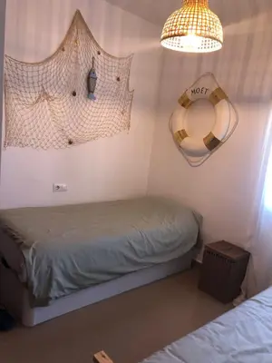 a bedroom with two beds and a chandelier at Terraza Mirador del Coto in Sanlúcar de Barrameda