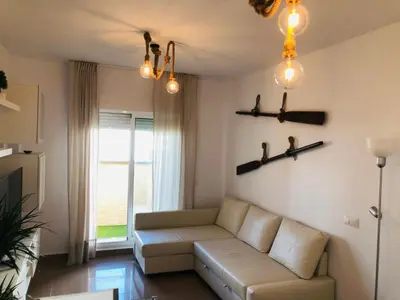 a living room with a couch and a window at Terraza Mirador del Coto in Sanlúcar de Barrameda