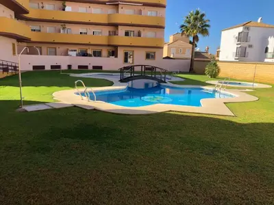 a swimming pool in a yard in front of a building at Terraza Mirador del Coto in Sanlúcar de Barrameda