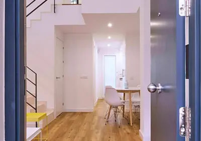 a room with a table and chairs and a staircase at Precioso duplex con patio junto a la Catedral in Cádiz
