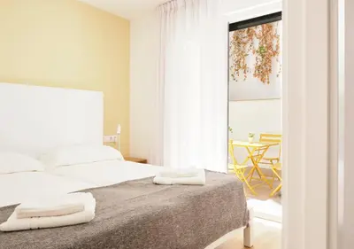 a bedroom with a bed with two towels on it at Precioso duplex con patio junto a la Catedral in Cádiz