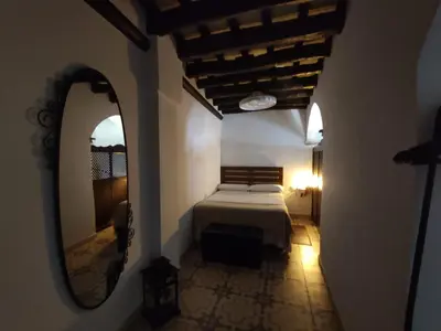 a bedroom with a bed and a mirror at CASA MONTAÑA in Arcos de la Frontera