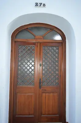 a wooden door with a glass window in a room at CASA MONTAÑA in Arcos de la Frontera