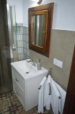 a bathroom with a sink and a mirror and towels at CASA MONTAÑA in Arcos de la Frontera