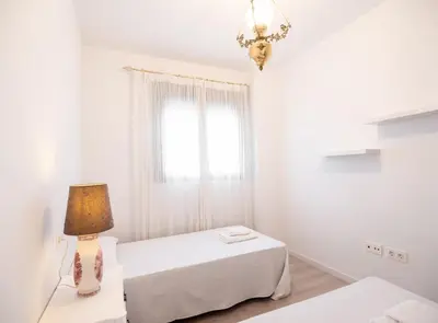 a white bedroom with two beds and a lamp at SibsSanlucar Manzanilla-Piscina-Terraza-BajoGuia-Playa-Centro in Sanlúcar de Barrameda