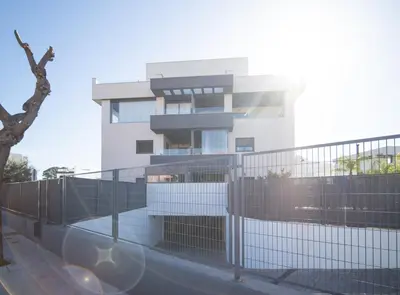 a white building with a fence in front of it at SibsSanlucar Manzanilla-Piscina-Terraza-BajoGuia-Playa-Centro in Sanlúcar de Barrameda