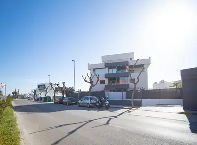 a street with a building with a motorcycle and a car at SibsSanlucar Manzanilla-Piscina-Terraza-BajoGuia-Playa-Centro in Sanlúcar de Barrameda