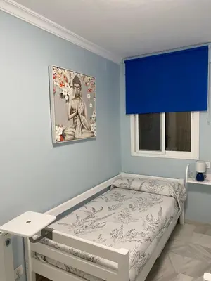 a bed in a room with a blue wall at Apartamento céntrico “Los Pajaritos” con garaje. in Jerez de la Frontera