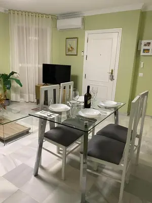 a dining room with a glass table and chairs at Apartamento céntrico “Los Pajaritos” con garaje. in Jerez de la Frontera