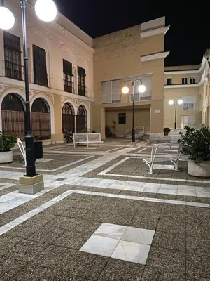 a large building with two tables and chairs in a courtyard at Apartamento céntrico “Los Pajaritos” con garaje. in Jerez de la Frontera