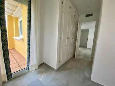 a hallway with white walls and a hallway with a door at Entre hoyos y la playa Grupo AC Gestion in Novo Sancti Petri