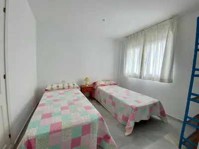 a room with two beds and a window at Entre hoyos y la playa Grupo AC Gestion in Novo Sancti Petri