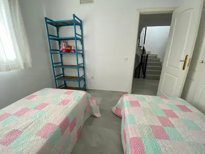 a bedroom with two beds next to a ladder at Entre hoyos y la playa Grupo AC Gestion in Novo Sancti Petri