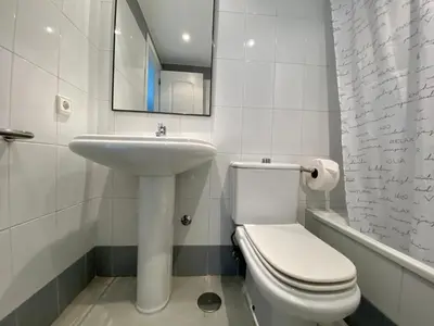 a white bathroom with a toilet and a sink at Entre hoyos y la playa Grupo AC Gestion in Novo Sancti Petri