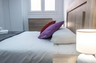 a bedroom with a bed with purple and white pillows at Brisa Marinera Grupo AC Gestion in Cádiz