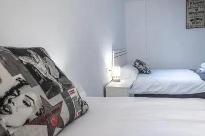 a bedroom with two beds and a lamp on a table at Brisa Marinera Grupo AC Gestion in Cádiz