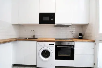 a kitchen with white cabinets and a washing machine at Precioso alojamiento en Cádiz junto al mercado in Cádiz