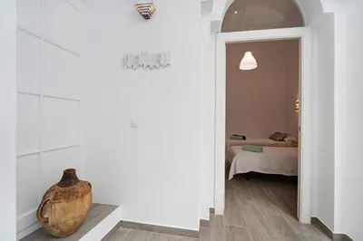a room with a vase on the floor and a bedroom at Precioso alojamiento en Cádiz junto al mercado in Cádiz