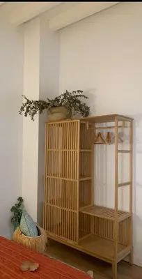 a wooden book shelf in a corner of a room at Pitusa Home in Cádiz