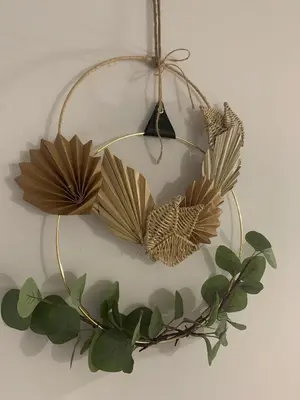 a wreath of leaves is hanging on a wall at Pitusa Home in Cádiz