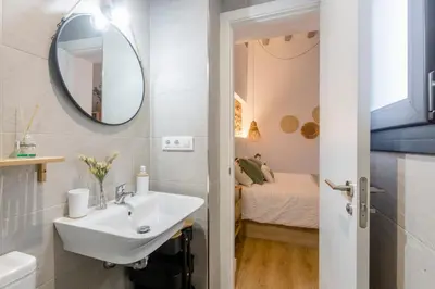 a bathroom with a sink and a mirror and a bed at Pitusa Home in Cádiz