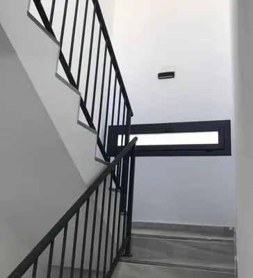 a stairway with a black rail and a white wall at Pitusa Home in Cádiz