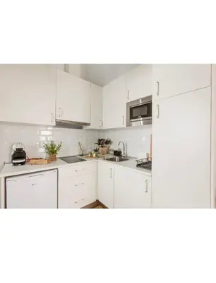 a white kitchen with white cabinets and a sink at Pitusa Home in Cádiz